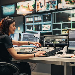 A person at a workstation surrounded by computers